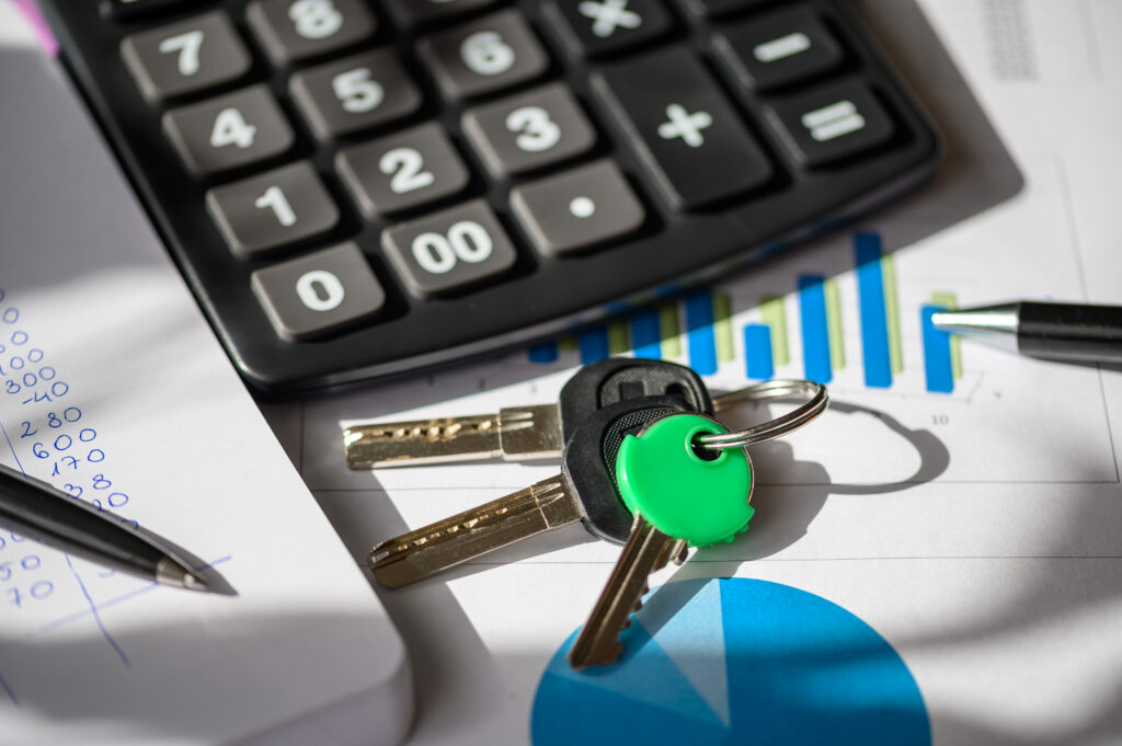 Close-up of a calculator, keys, and financial documents on a table